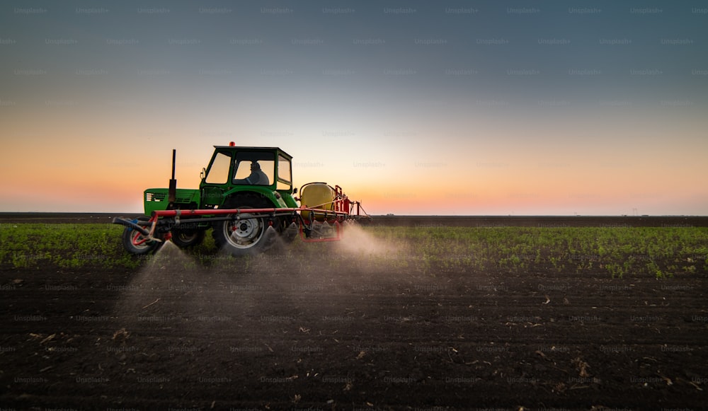 Tracteur pulvérisant des pesticides dans les champs de soja