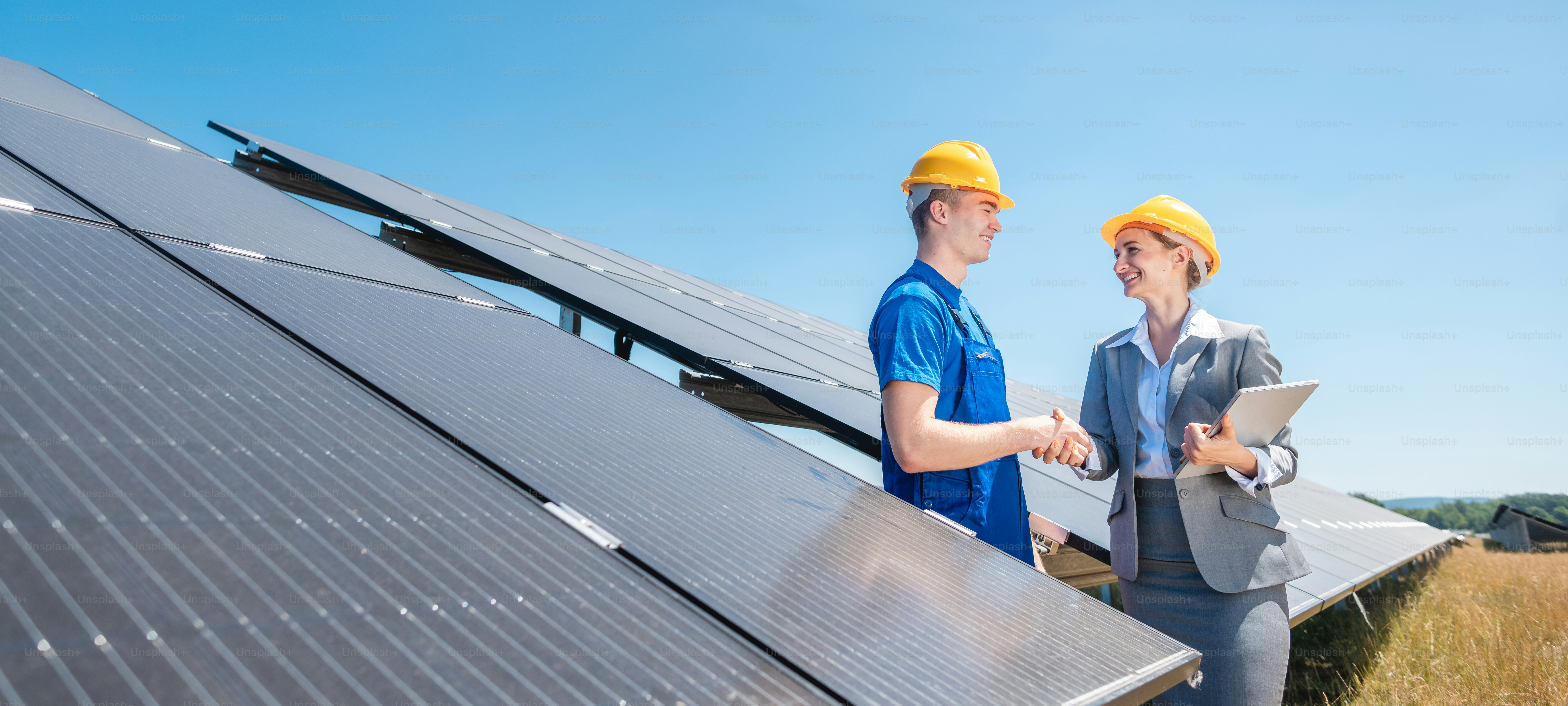 Construction worker and investor in solar power plant shaking hands after completion of the project