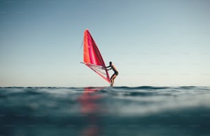 Vista ad angolo basso del surfista in equilibrio sulla tavola da windsurf.