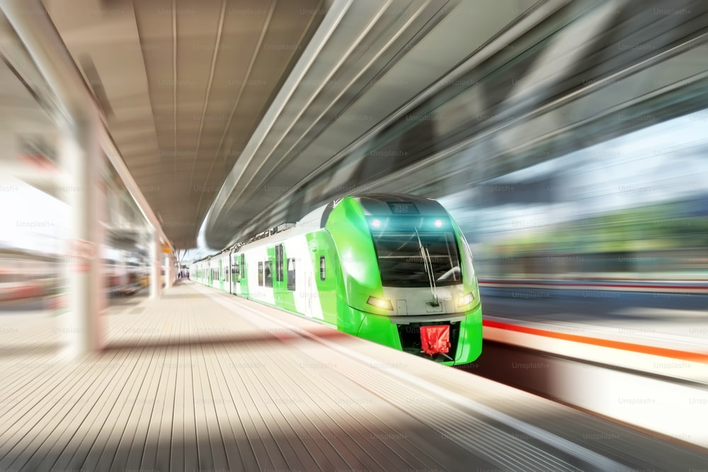 High speed train in motion on the railway station. Modern intercity passenger train with motion blur effect on the railway platform. Railroad commercial transportation