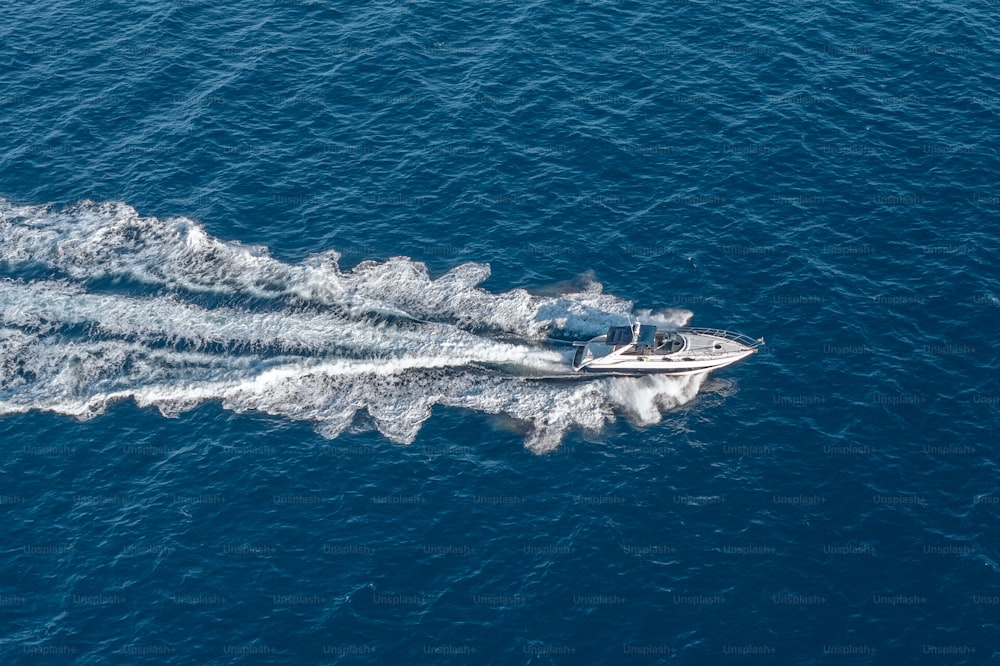 The boat floats at high speed on the blue expanse of sea water, top view