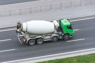 고속도로에서 운전하는 콘크리트 믹서 트럭이 있는 트럭