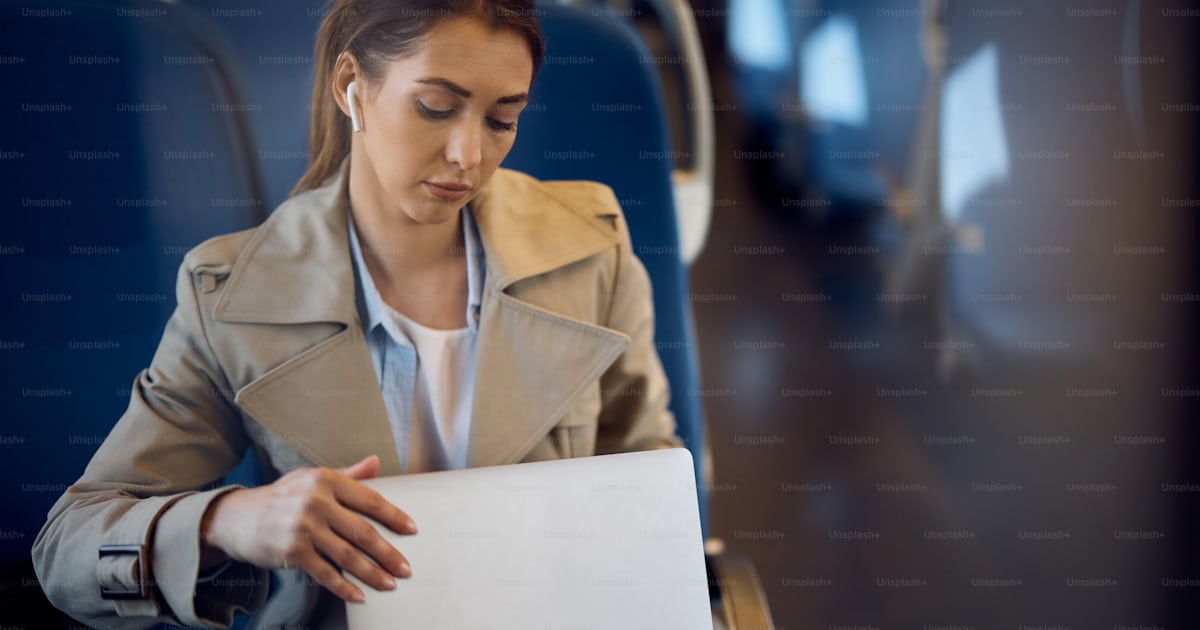 Young woman using her computer while commuting to work by train. photo ...
