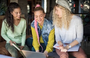 Technology as an aid in everything. Three students at cafe learning. Focus on foreground."n