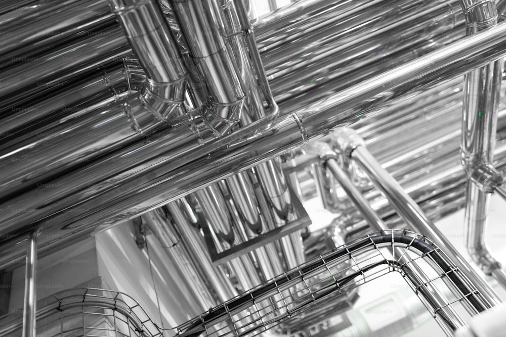生乳工場の鋼管。工業地帯、鋼鉄パイプラインおよび弁。蒸気パイプラインと鉄骨構造。産業用発電所の内部にある機器、ケーブル、配管
