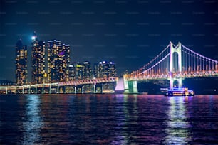 夜にライトアップされた広安大橋と高層ビル。韓国、釜山
