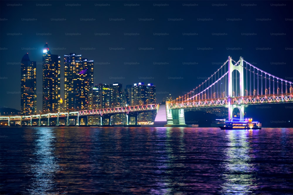 El puente Gwangan y los rascacielos iluminados por la noche. Busan, Corea del Sur
