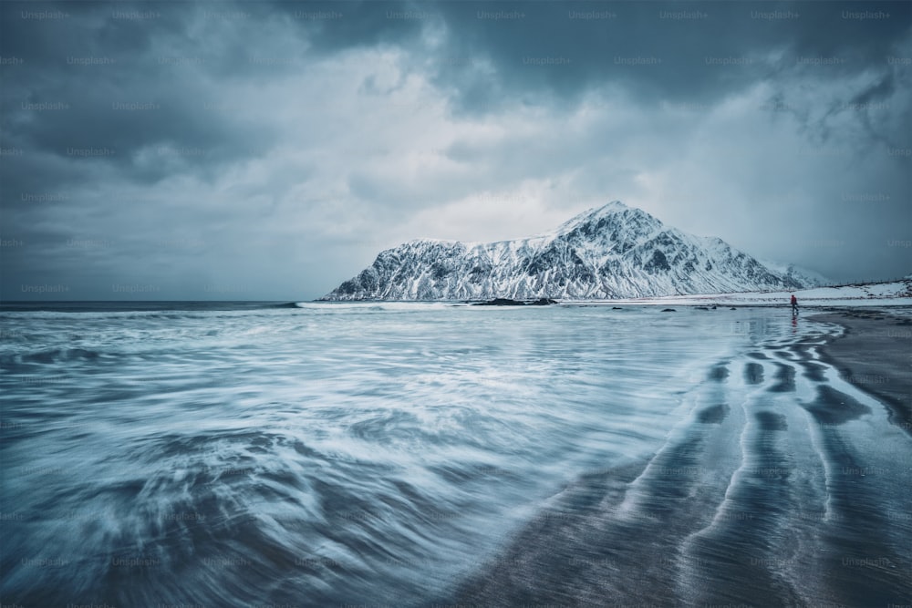 Waves on coast of Norwegian sea in fjord. Skagsanden beach, Flakstad, Lofoten islands, Norway. Long exposure motion blur