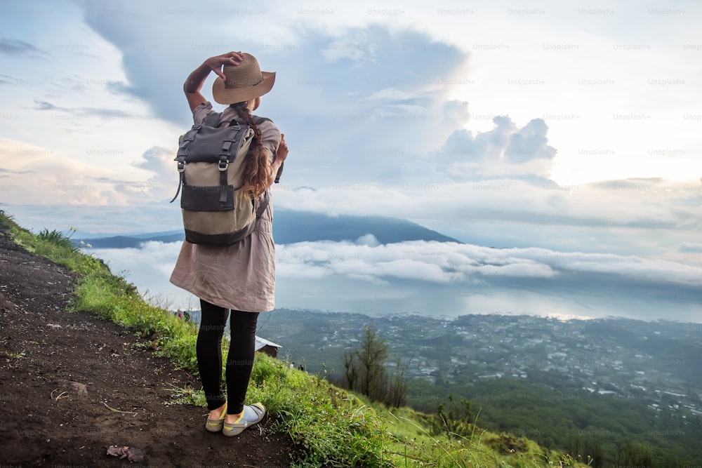 インドネシア、バリ島、バトゥール山の頂上から日の出を楽しむ女性。