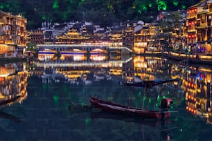 Destination d’attraction touristique chinoise - Ancienne ville de Feng Huang (ancienne ville de Phoenix) sur la rivière Tuo Jiang illuminée la nuit. Province du Hunan, Chine