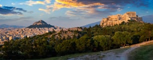 Panorama of famous greek tourist landmark - the iconic Parthenon Temple at the Acropolis of Athens as seen from Philopappos Hill on sunset. Athens, Greece