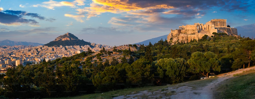 Panorama of famous greek tourist landmark - the iconic Parthenon Temple at the Acropolis of Athens as seen from Philopappos Hill on sunset. Athens, Greece