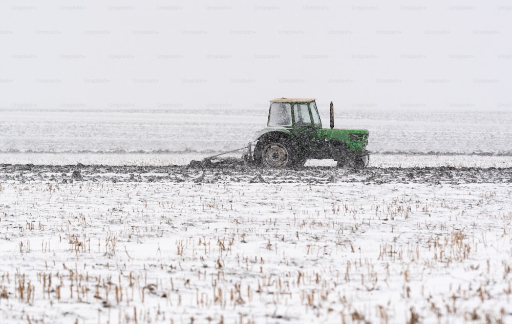冬の間に無精ひげ畑を耕すトラクター