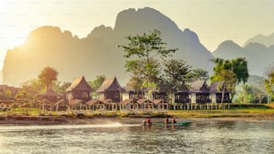 Villaggio e bungalow lungo il fiume Nam Song a Vang Vieng, Laos.