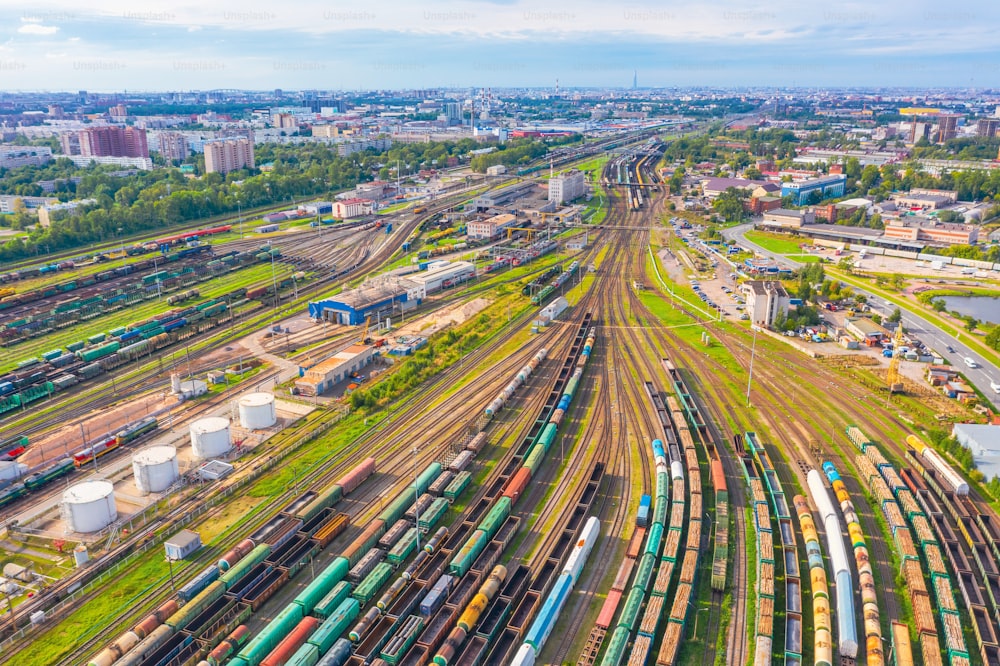 Cargo railway carriage. Aerial view from flying drone of colorful freight trains on the railway sort facility. Wagons with goods on railroad. Heavy industry, industrial scene