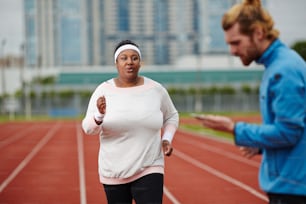 Junge übergewichtige Frau nimmt am Laufmarathon teil