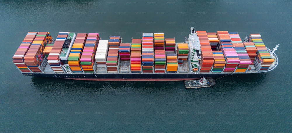 Container aerei con vista dall'alto, attività di carico, commercio commerciale, logistica e trasporto di importazioni ed esportazioni internazionali da parte di una nave da carico per container nel porto marittimo aperto.