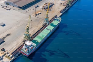 Luftaufnahme Draufsicht riesiges Frachtschiff, das am Pier am Hafen vor Anker liegt, lädt Waren, Containerladung