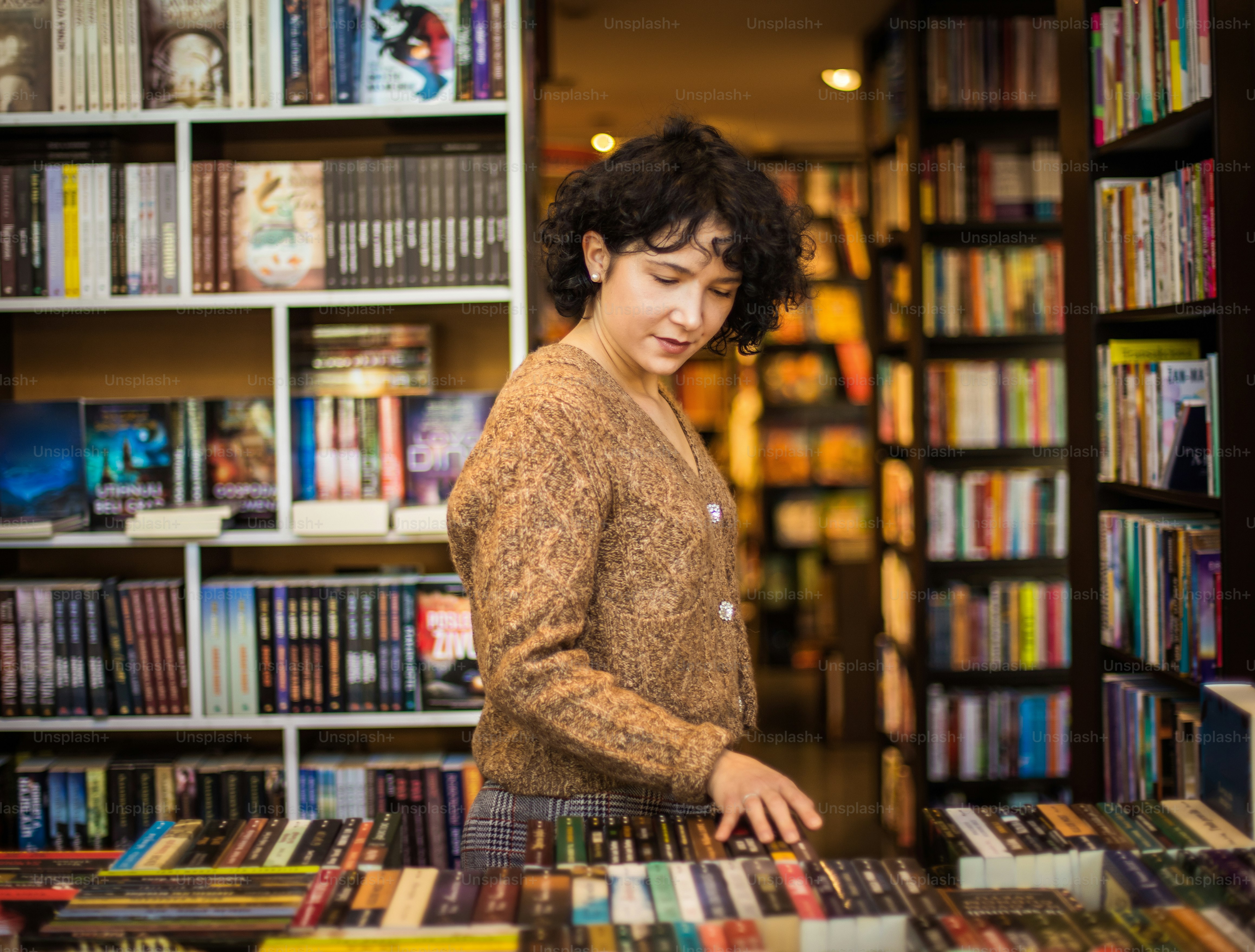 Mujer en la biblioteca eligiendo el libro.