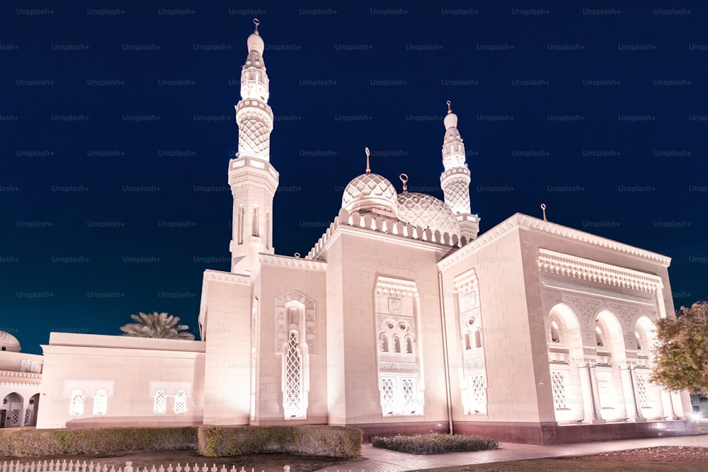 Mesquita Jumeirah iluminada à noite em Dubai, Emirados Árabes Unidos. É também um centro educacional para a compreensão cultural. Conceito de religião muçulmana