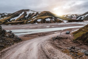 아이슬란드, 유럽의 고원에 있는 아름다운 Landmanalaugar 자갈 먼지 도로 길. 극단적 인 4WD 4x4 차량을위한 진흙 투성이의 거친 지형. 란드마날뢰이가르 풍경은 자연 트레킹과 하이킹으로 유명합니다.