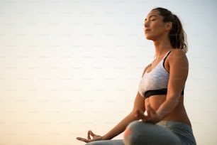 Low angle view of woman with eyes closed practicing Yoga against the sky. Copy space.