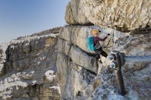 jolie alpiniste blonde sur une Via Ferrata raide au-dessus de Cortina d’Ampezzo