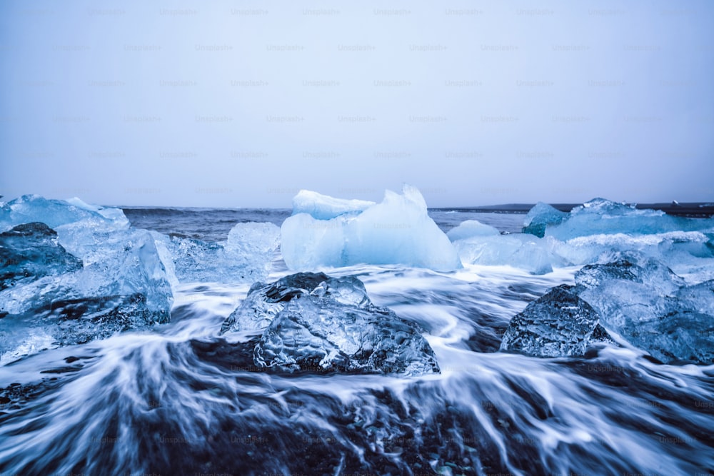 Icebergs on Diamond Beach in Iceland. Frozen ice on black sand beach known as Diamond Beach flows from Jokulsarlon beautiful Glacial Lagoon in Vatnajokull National Park, southeast Iceland, Europe.