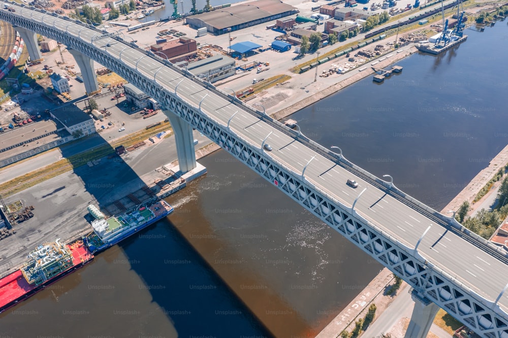 Autopista sobre la zona industrial de la ciudad y el canal del mar, vista aérea desde arriba