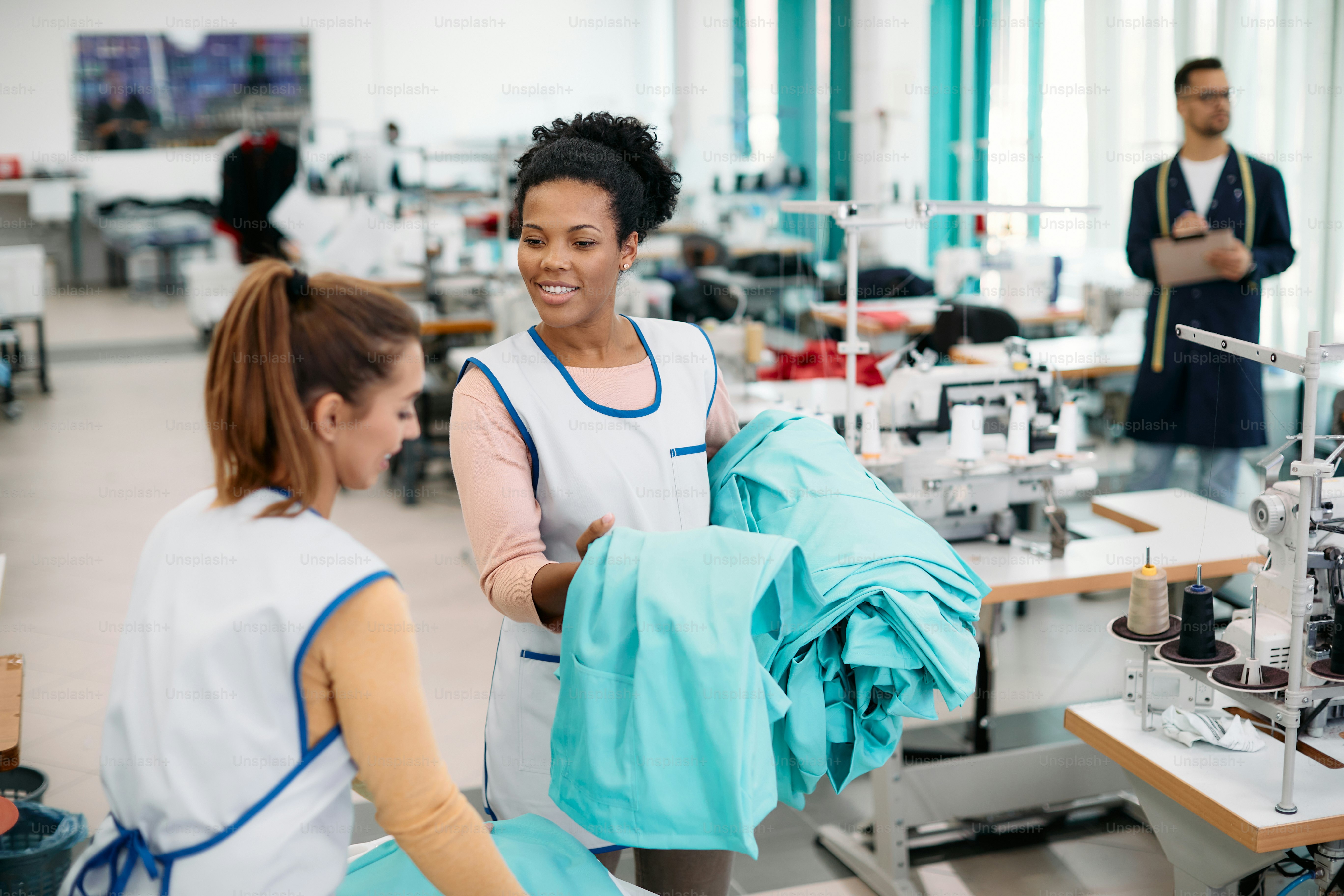 Happy African American dressmaker communicating with her female ...