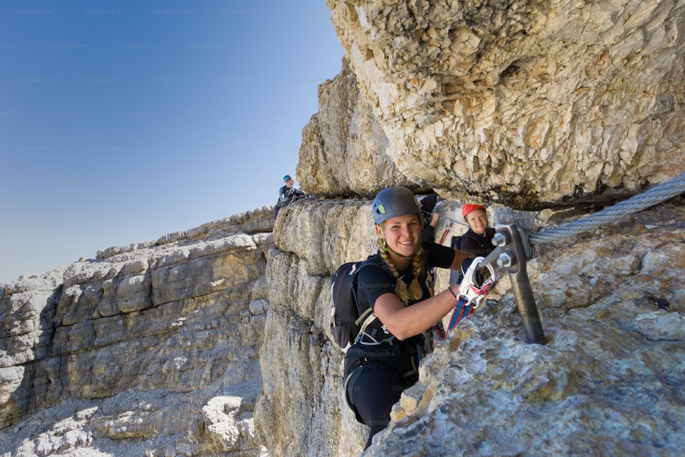 plusieurs jeunes alpinistes sur une Via Ferrata très exposée à Alta Badia dans les Dolomites italiennes