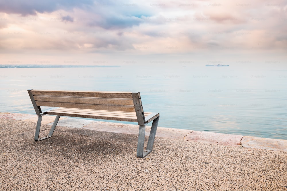 Una piattaforma panoramica con una panchina romantica solitaria sull'argine vicino al mare calmo