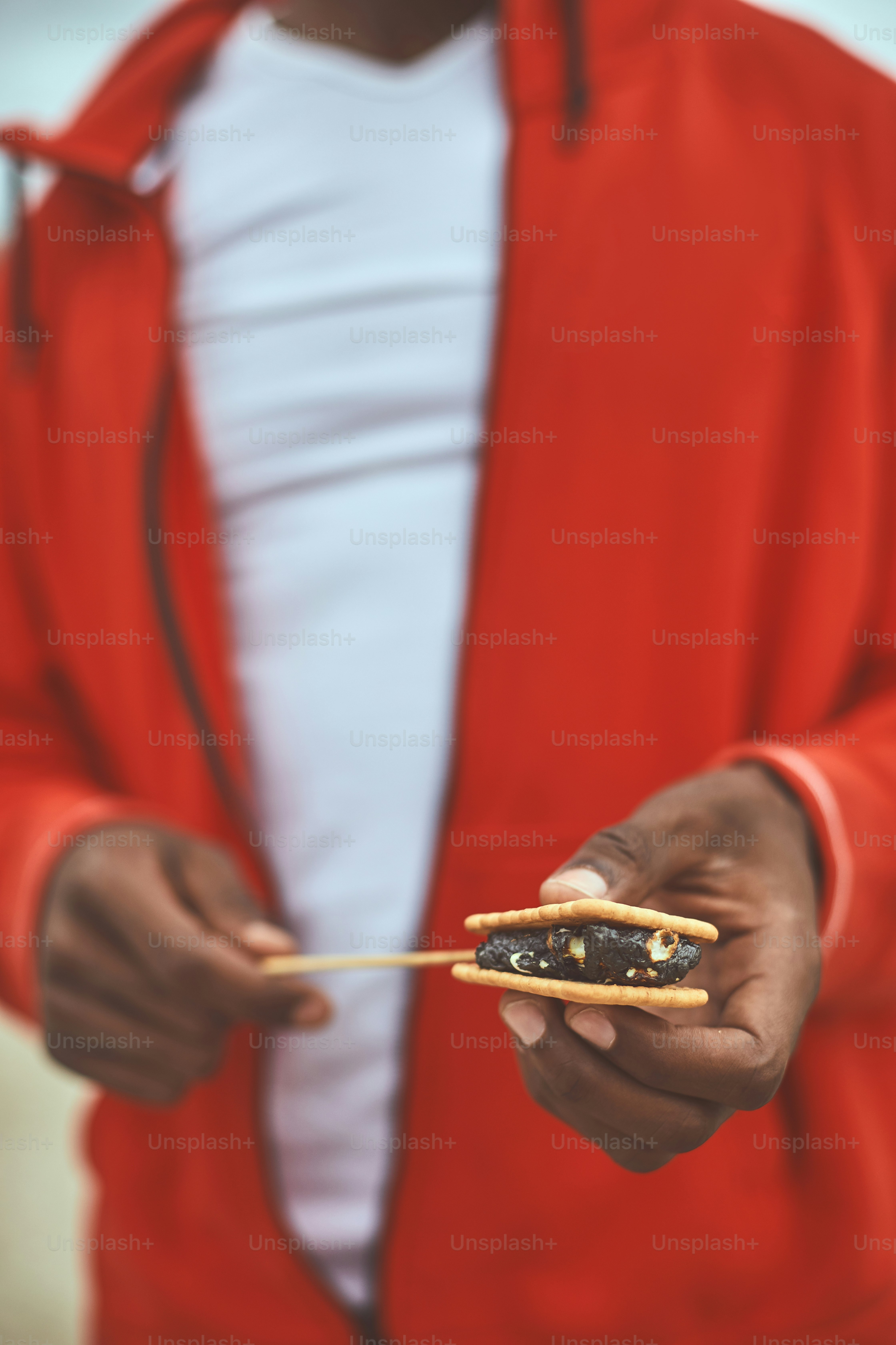 Sweet pastry. Close up of human hand holding cracker with filling