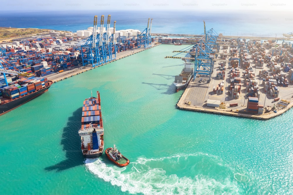 Cargo avec plusieurs conteneurs navigue dans le port maritime du port avec grue industrielle, pour le déchargement. Concept de l’industrie du transport maritime.