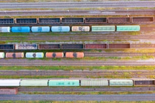 Luftaufnahme verschiedener Eisenbahnwaggonzüge mit Güter auf dem Bahnhof, Draufsicht