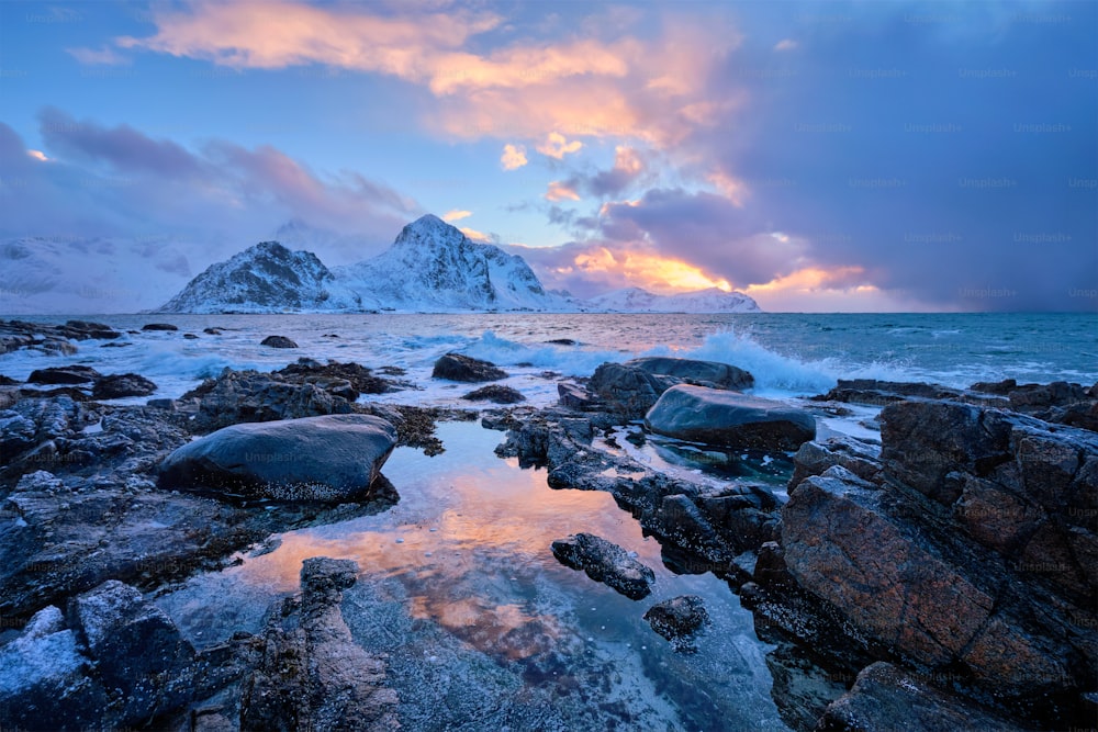 겨울에 해질녘에 피요르드의 바위 해안에 있는 노르웨이 바다의 해변. 바레이드 해변, 로포텐 섬, 노르웨이