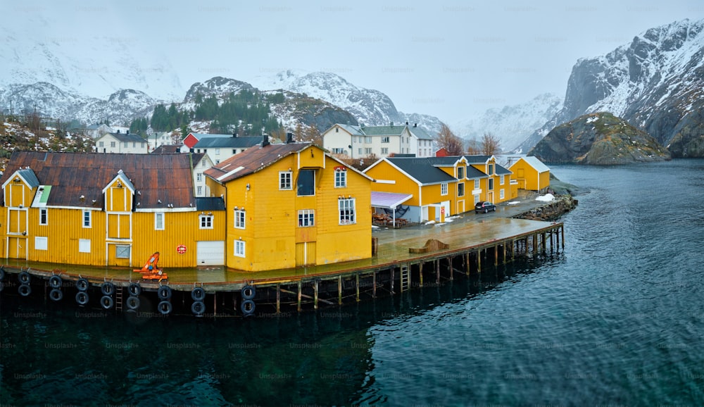 冬のノルウェーのフィヨルドにある黄色いロルブの家があるヌスフィヨルドの本格的な漁村のパノラマ。ロフォーテン諸島、ノルウェー