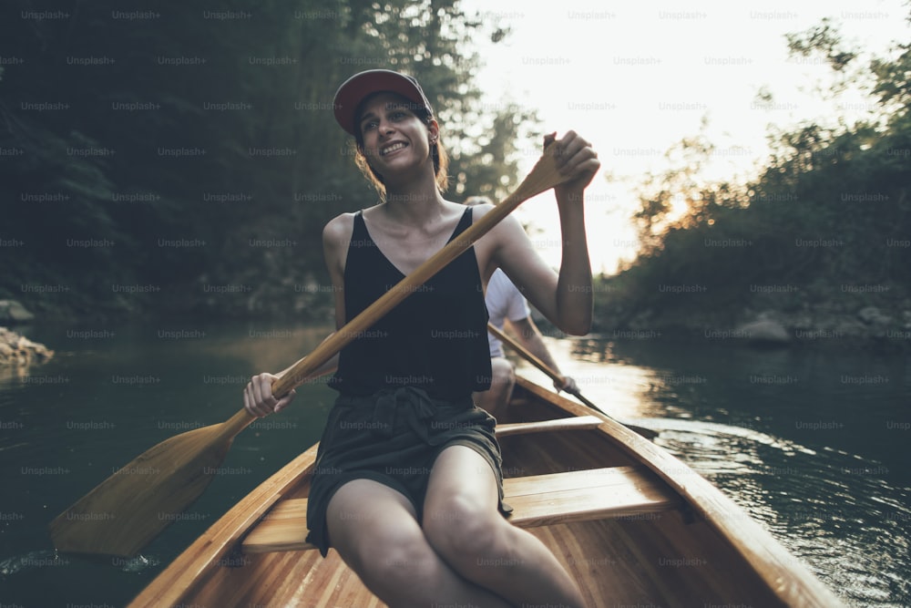 Mujer remando en canoa en un lago del bosque, espacio de copia.