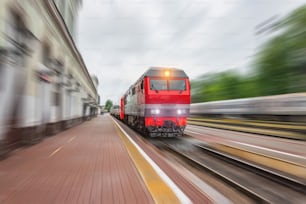 Locomotiva diesel com um trem de passageiros com um vagão corre ao longo da ferrovia