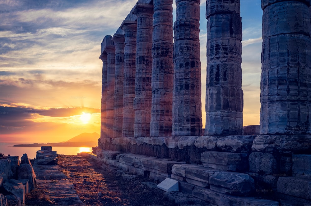 ギリシャ、スーニオ岬。夕暮れ時のギリシャ神話の海の神ポセイドンの古代神殿の遺跡。夕暮れ時の寺院遺跡のショット。アッティカの観光名所、スニオン、ギリシャ