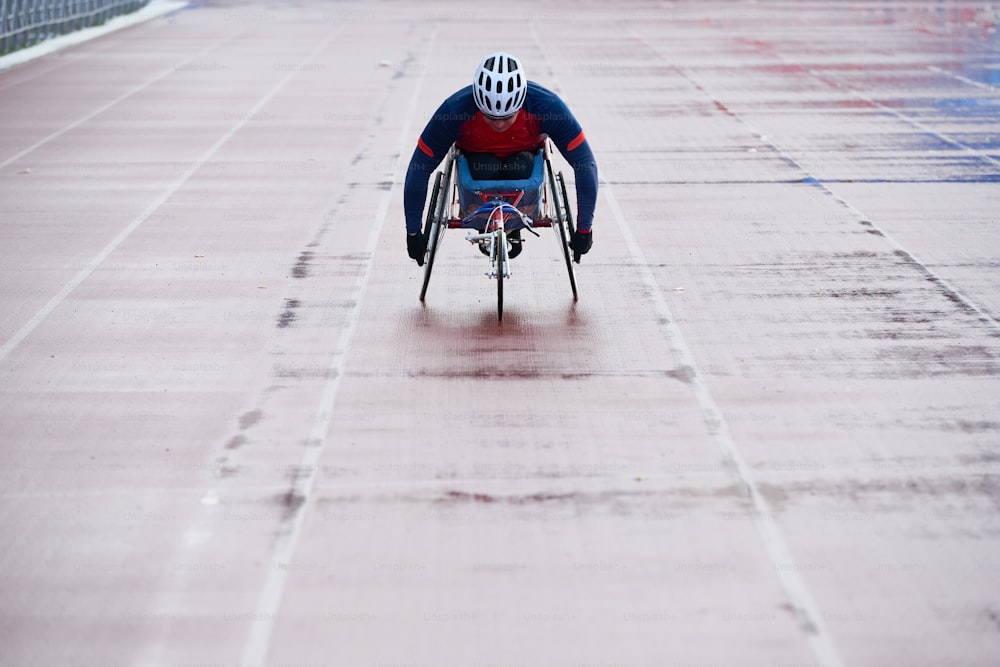 Wheelchair athletics. Paralympic champion in sport wheelchair approaching finish line while having racing competition at outdoor track and field stadium