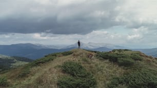 L'uomo in piedi sullo sfondo delle belle montagne