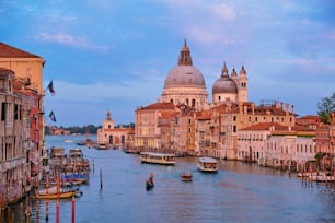 Panorama sur le Grand Canal de Venise avec des gondoles et l’église Santa Maria della Salute au coucher du soleil depuis le pont de l’Accademia. Venise, Italie