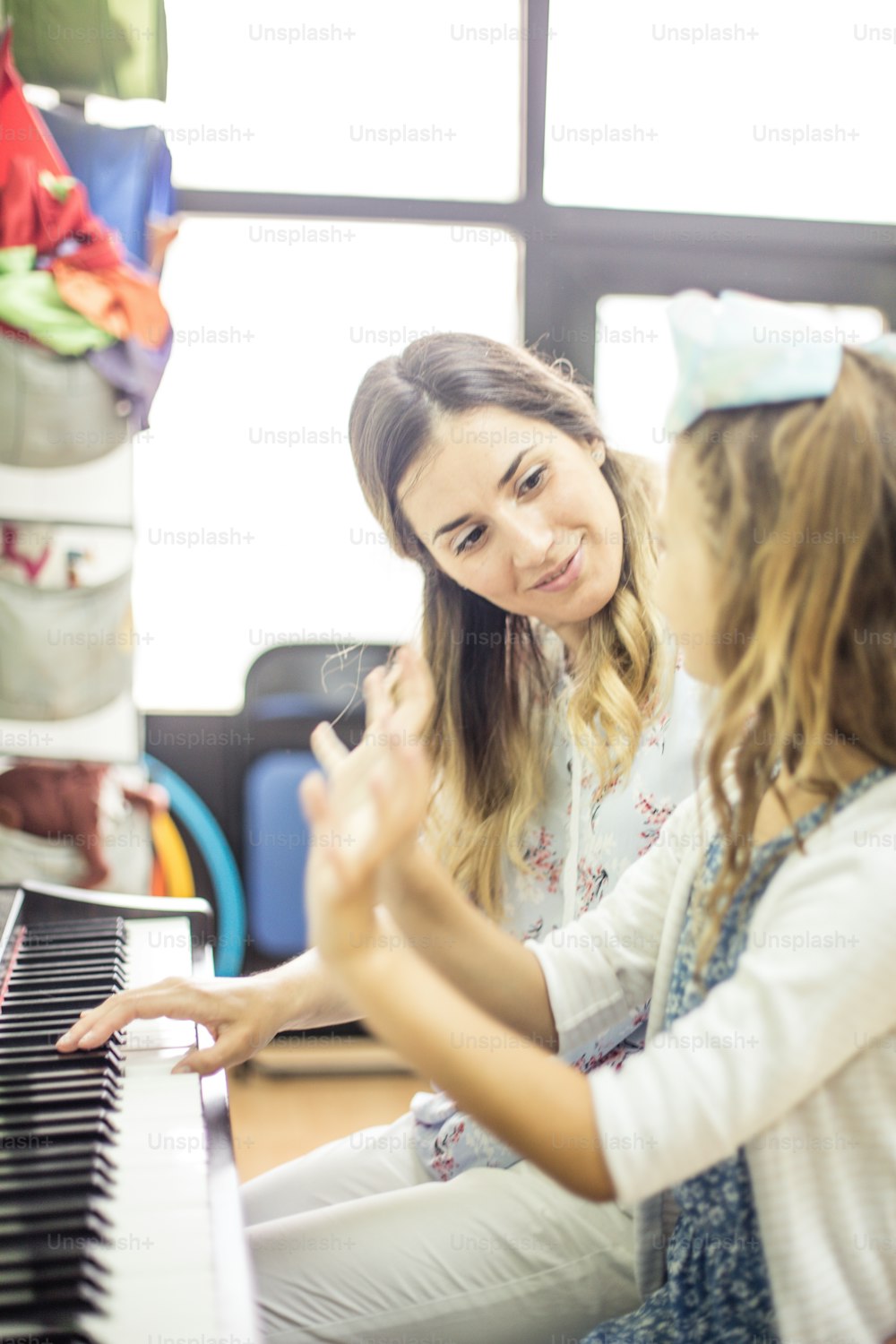 Miniature maestro. Child in music school with teacher.