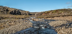 Shallow river stream nature terrain in countryside. Four-wheel drive vehicle track.