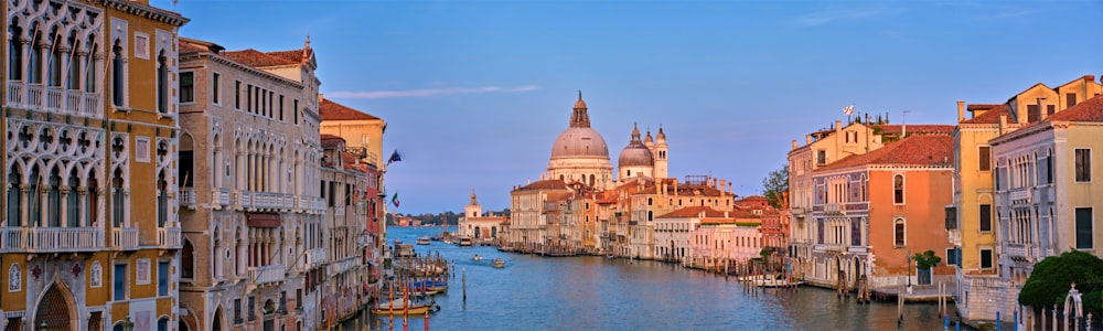 Panorama do Grande Canal de Veneza com barcos e igreja de Santa Maria della Salute ao pôr do sol da Ponte dell'Accademia. Veneza, Itália
