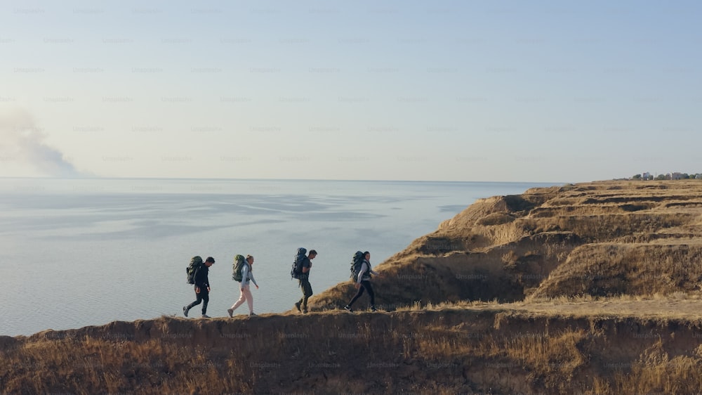 岩だらけの海岸線を歩く4人の観光客