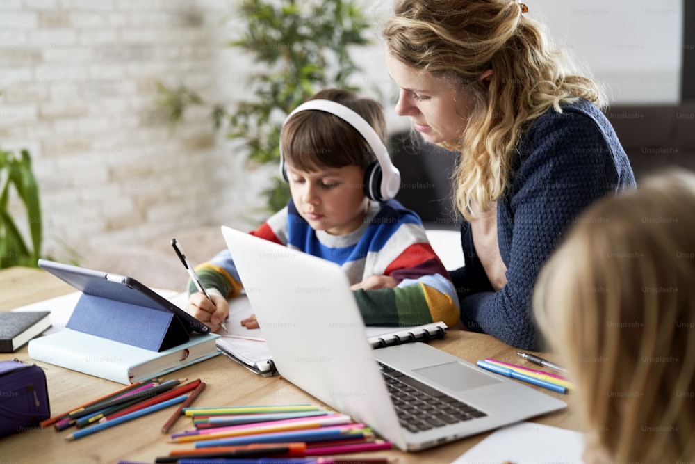 自宅で勉強しながら息子を手伝う母親