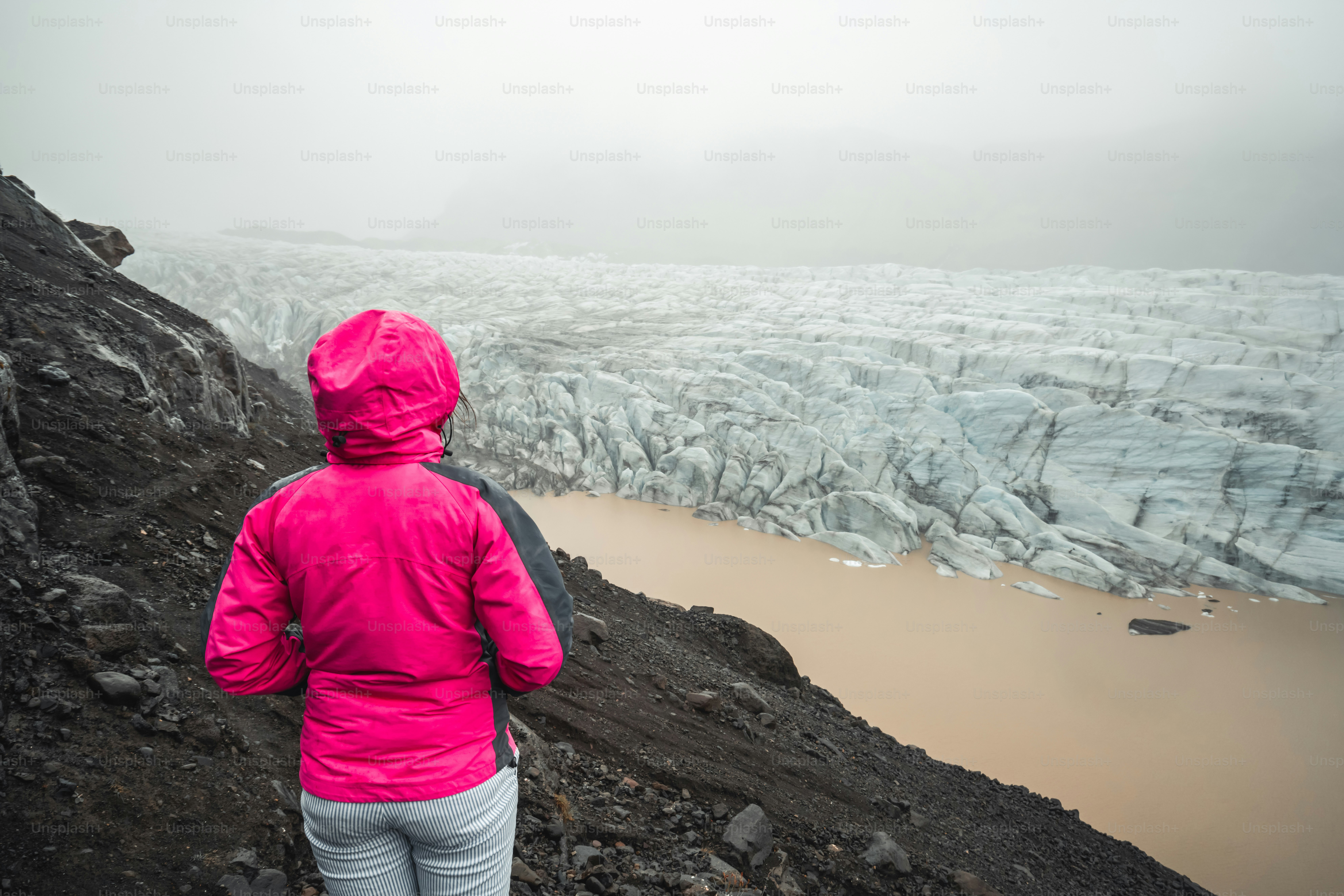 Woman traveler travels at beautiful scenery landscape of Svinafellsjokull Glacier lake, tourism destination in Vatnajokull National Park in Iceland. Cold winter ice landscape.
