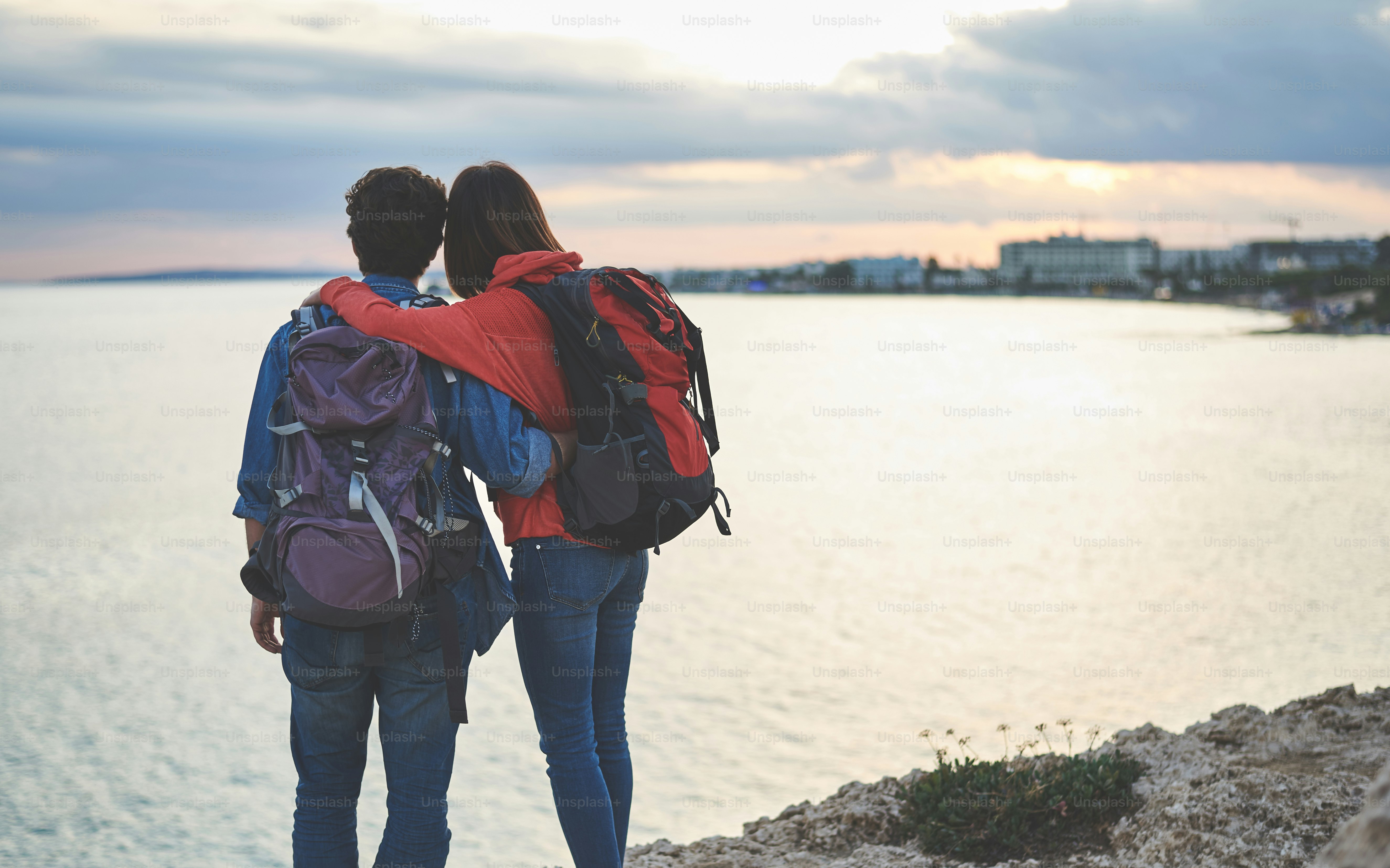 Les touristes calmes profitent de la vue sur la mer tout en se tenant sur le rocher. Ils s’embrassent avec amour tout en se retournant
